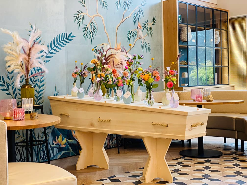 uitvaartkist met potten en bloemen